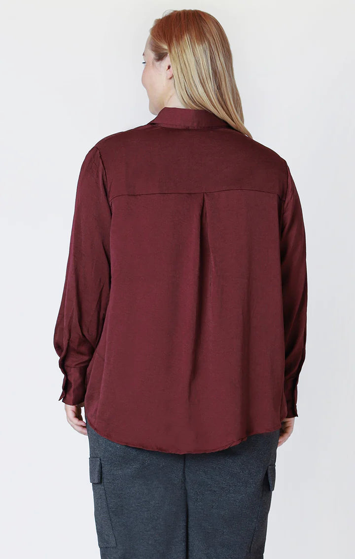Back View: Burgundy satin blouse with high-low hem and full-length sleeves – elegant and flowy design