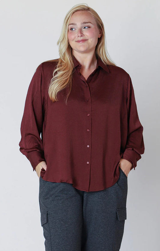 Front View: Burgundy satin blouse with button front and collared neckline – relaxed fit and soft drape
