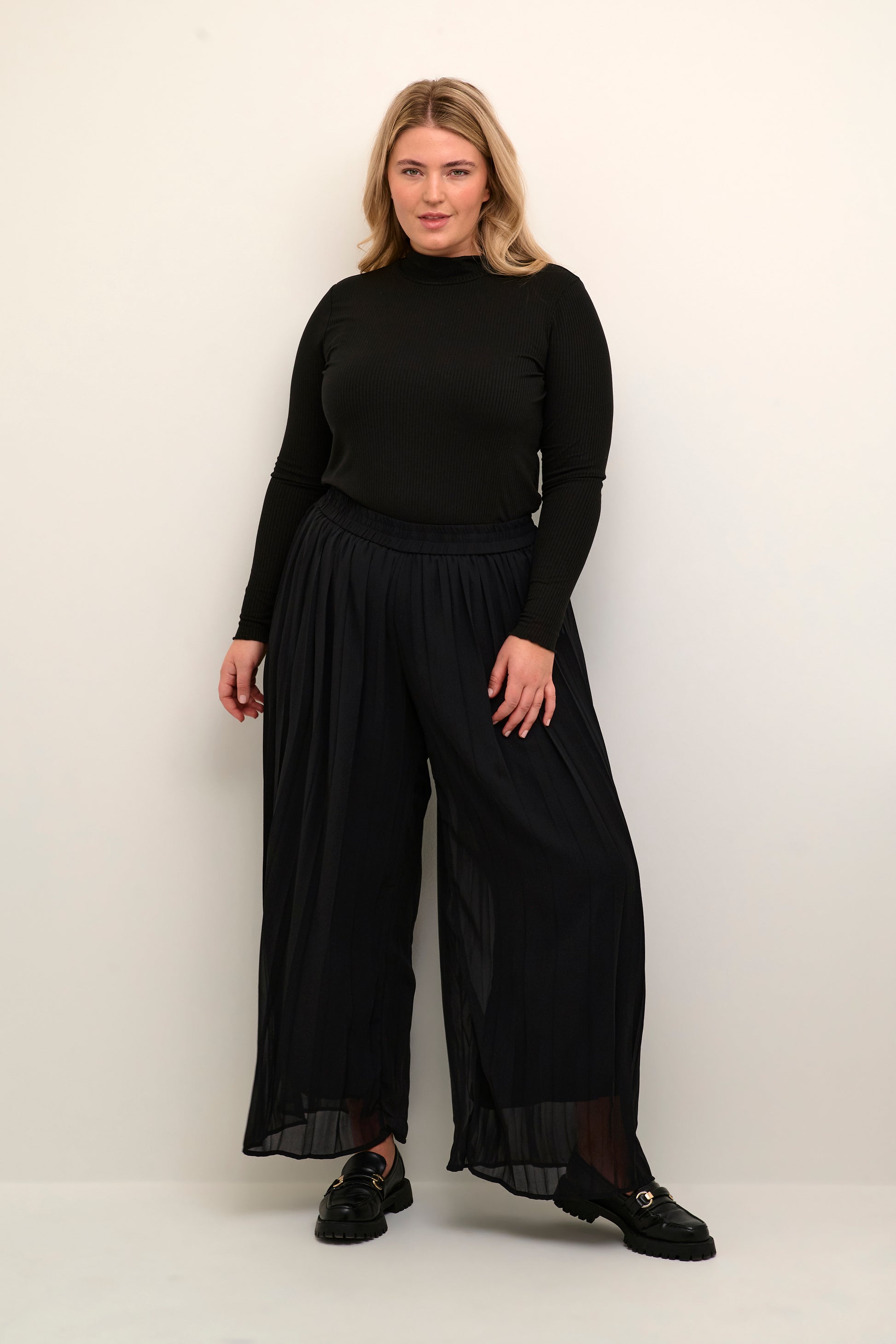 Model wearing Kaffe Curve KCferi black pleated wide leg pant. Available at Pinned Up Bra Lounge in Markham, Ontario