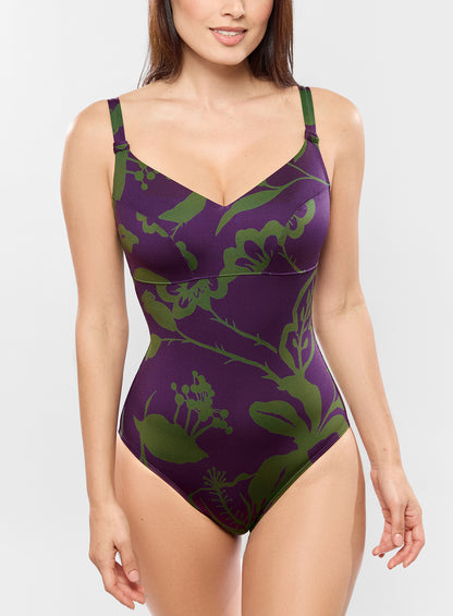 Purple swimsuit with green floral pattern worn by a model on a white background